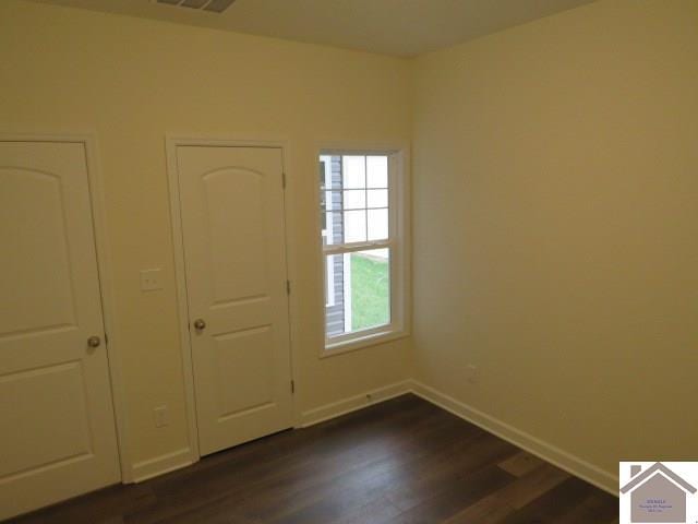 unfurnished bedroom featuring dark hardwood / wood-style flooring