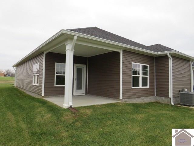 rear view of property with a yard, central AC unit, and a patio