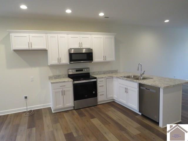 kitchen with sink, stainless steel appliances, white cabinetry, and dark hardwood / wood-style floors