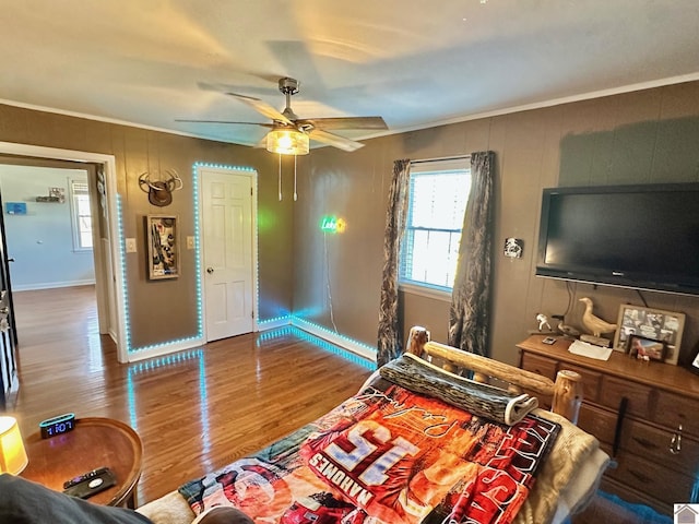 bedroom featuring hardwood / wood-style floors, ornamental molding, and ceiling fan