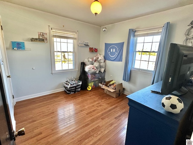 interior space featuring hardwood / wood-style flooring, crown molding, and a healthy amount of sunlight