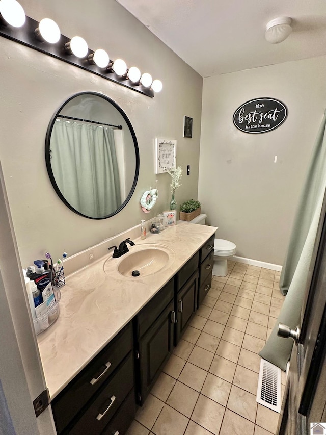 bathroom featuring vanity, tile patterned floors, and toilet