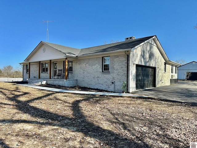 back of house featuring a garage and covered porch