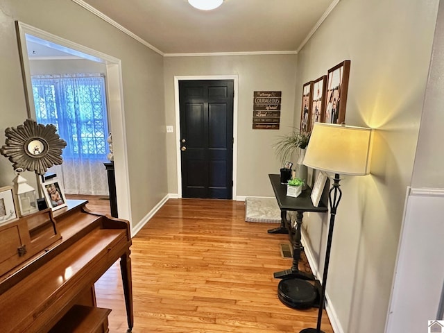 entryway with ornamental molding and light hardwood / wood-style flooring