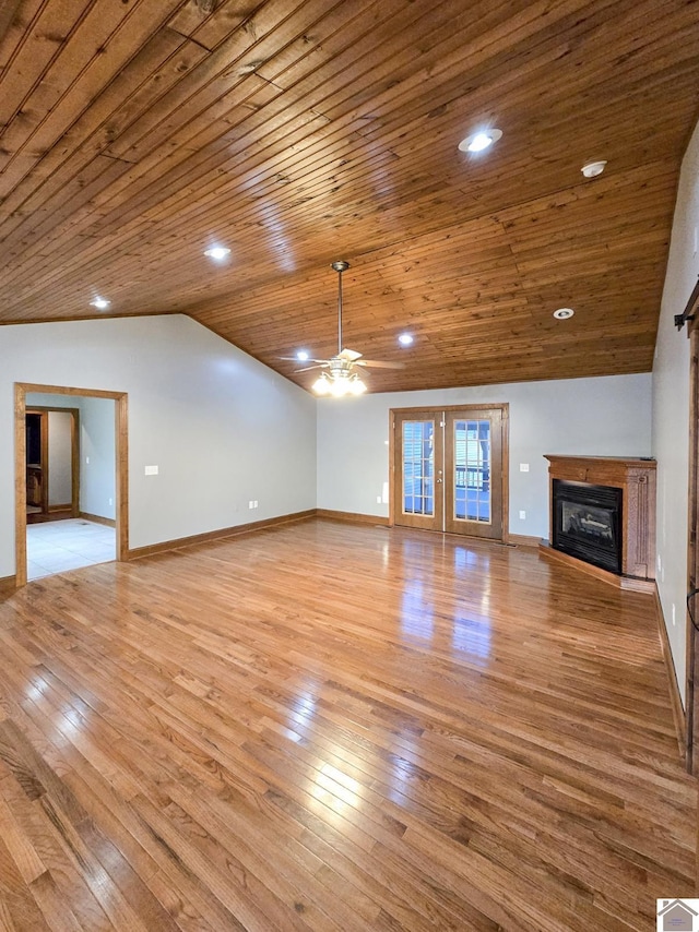 unfurnished living room with wood ceiling, lofted ceiling, light hardwood / wood-style flooring, and french doors