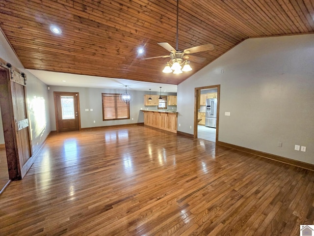 unfurnished living room with wood ceiling, lofted ceiling, a barn door, and hardwood / wood-style flooring