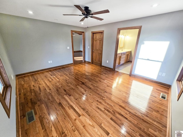 unfurnished bedroom featuring ceiling fan, connected bathroom, and light wood-type flooring