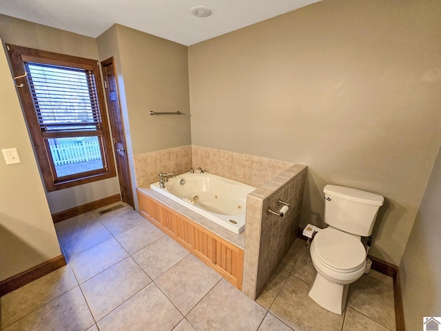 bathroom featuring a tub to relax in, toilet, and tile patterned flooring