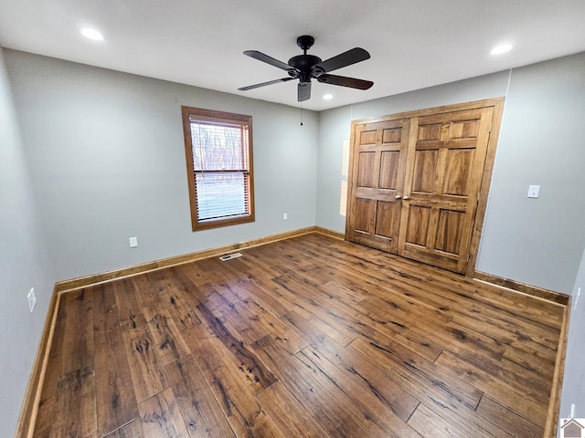 unfurnished bedroom with hardwood / wood-style flooring, ceiling fan, and a closet