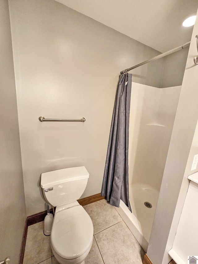 bathroom with walk in shower, tile patterned floors, and toilet