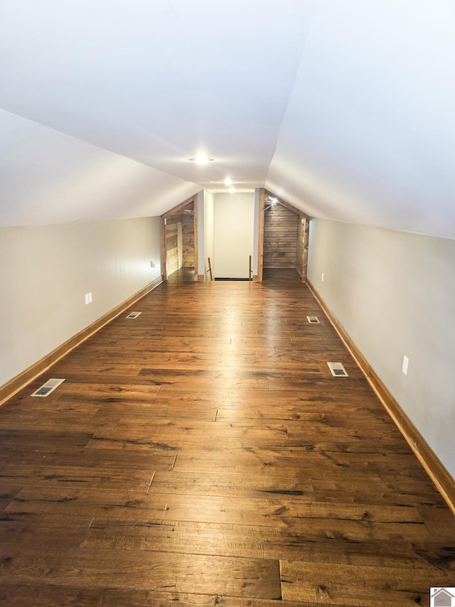 bonus room with lofted ceiling and dark wood-type flooring