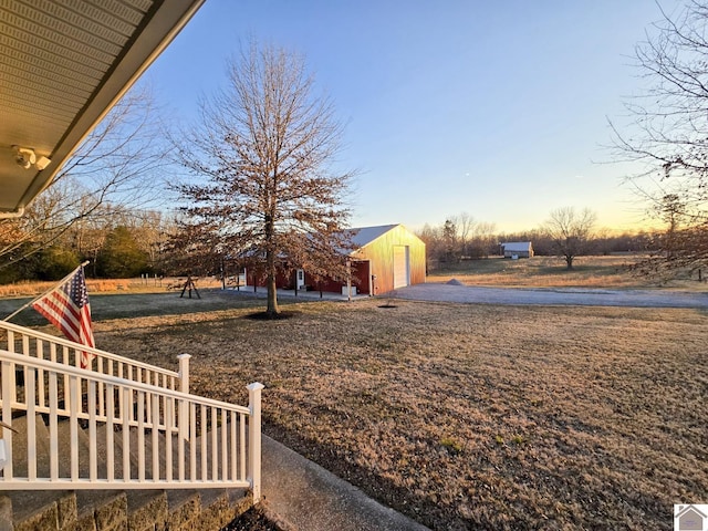 yard at dusk featuring a garage