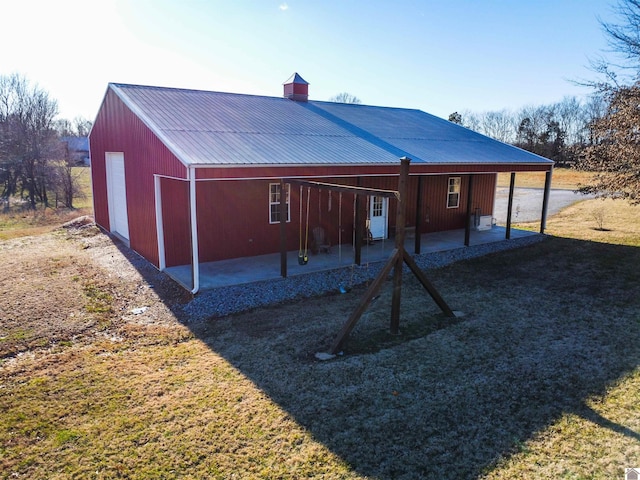 rear view of property with an outbuilding and a yard