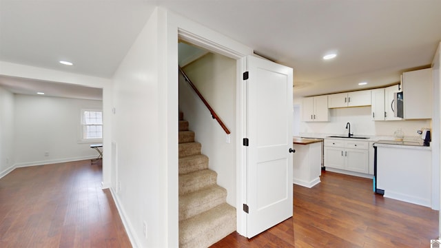 stairs featuring sink and hardwood / wood-style floors