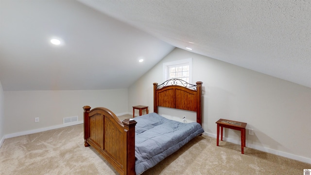 carpeted bedroom with vaulted ceiling and a textured ceiling