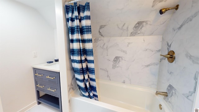 bathroom featuring vaulted ceiling, shower / bathtub combination with curtain, and vanity