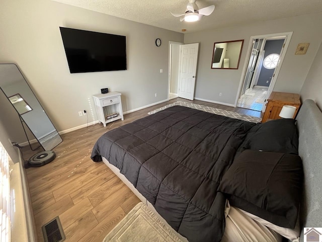 bedroom with hardwood / wood-style flooring, a textured ceiling, and ceiling fan