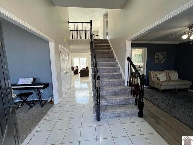 staircase with tile patterned flooring and crown molding