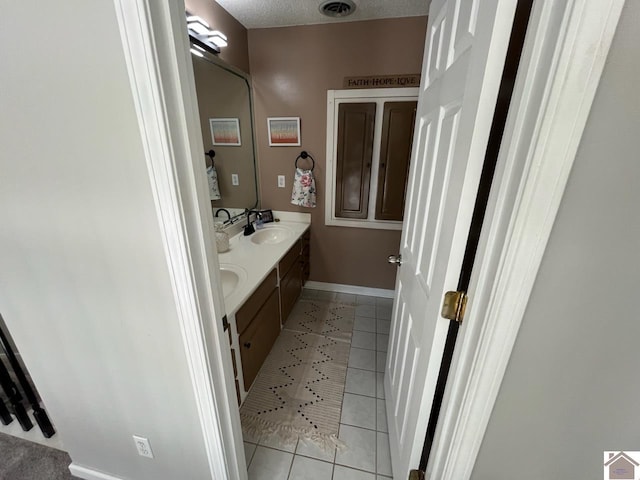 bathroom with tile patterned floors, vanity, and a textured ceiling