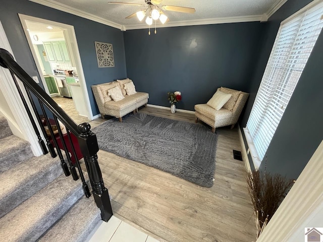 sitting room featuring crown molding, a textured ceiling, and ceiling fan