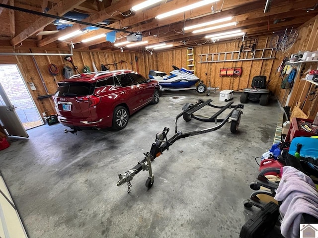 garage with a garage door opener and wooden walls