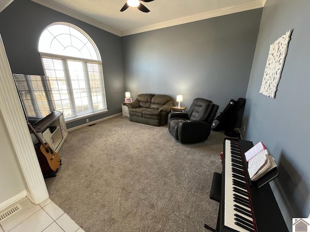 living room featuring ornamental molding, light carpet, a textured ceiling, and ceiling fan