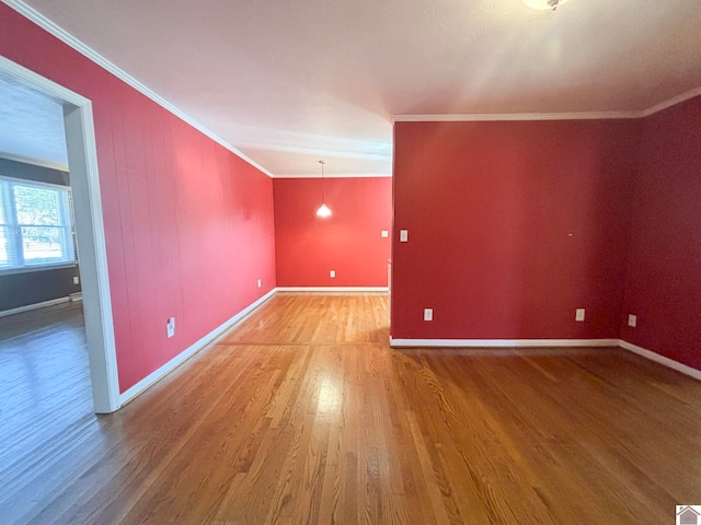 spare room with hardwood / wood-style flooring and crown molding