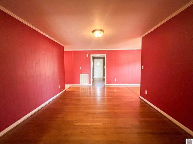 spare room featuring hardwood / wood-style flooring and ornamental molding