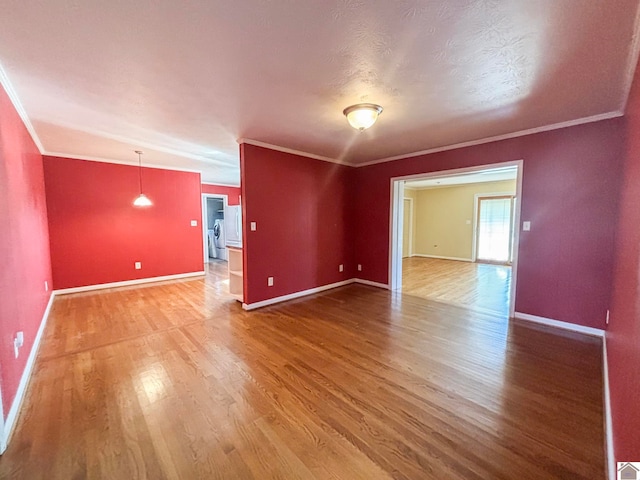 empty room with hardwood / wood-style floors, ornamental molding, and a textured ceiling