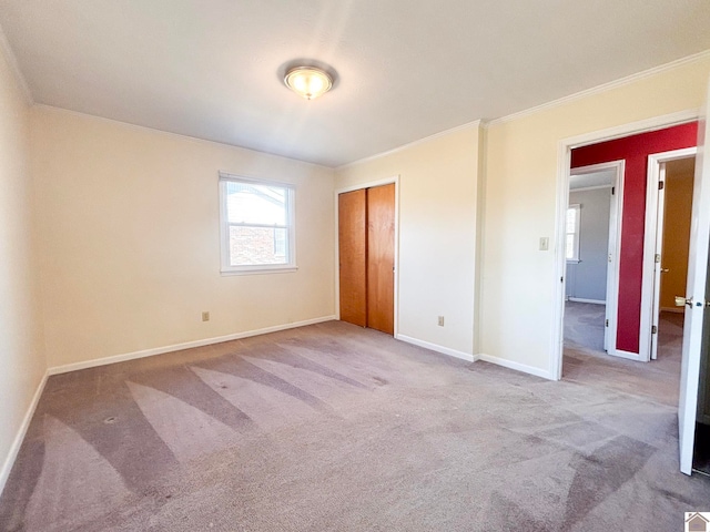 unfurnished bedroom featuring ornamental molding, light colored carpet, and a closet