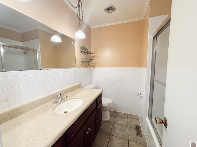 full bathroom with tile patterned floors, toilet, crown molding, tile walls, and vanity