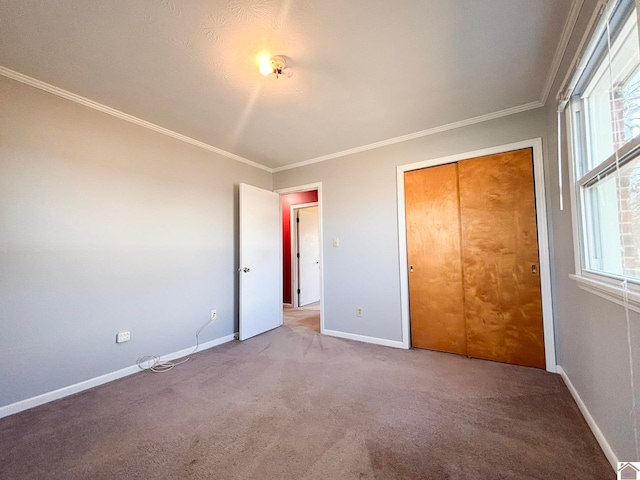 unfurnished bedroom featuring crown molding, multiple windows, carpet, and a closet