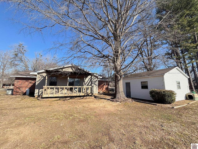 back of house with a wooden deck and a yard