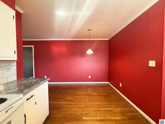 kitchen featuring white cabinetry, ornamental molding, hardwood / wood-style floors, and hanging light fixtures