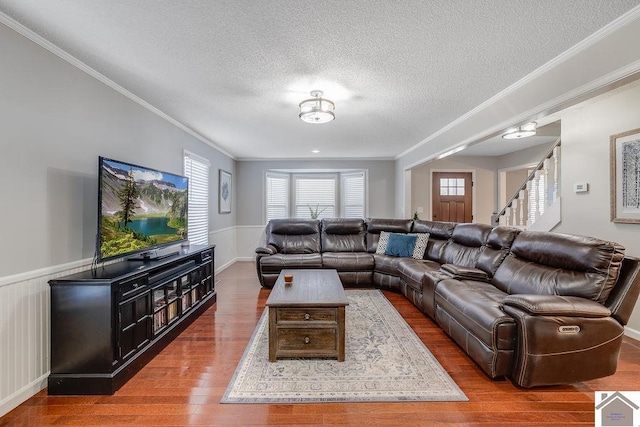 living room featuring hardwood / wood-style flooring, crown molding, and a textured ceiling