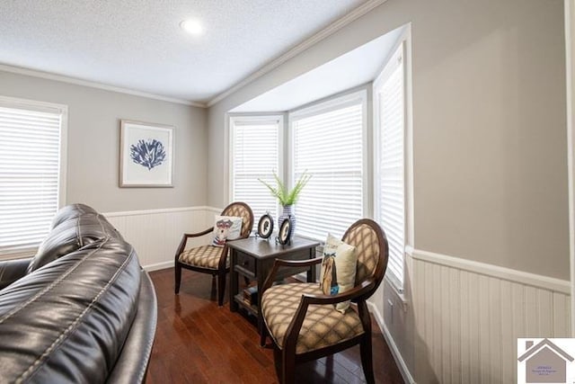 living area with crown molding, dark hardwood / wood-style flooring, and a textured ceiling