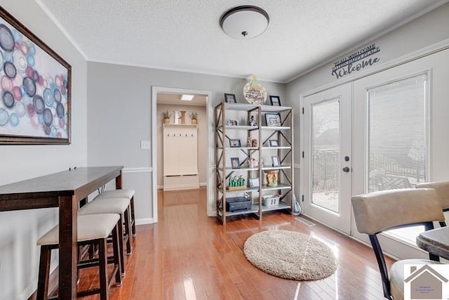 interior space featuring hardwood / wood-style floors, a textured ceiling, and french doors