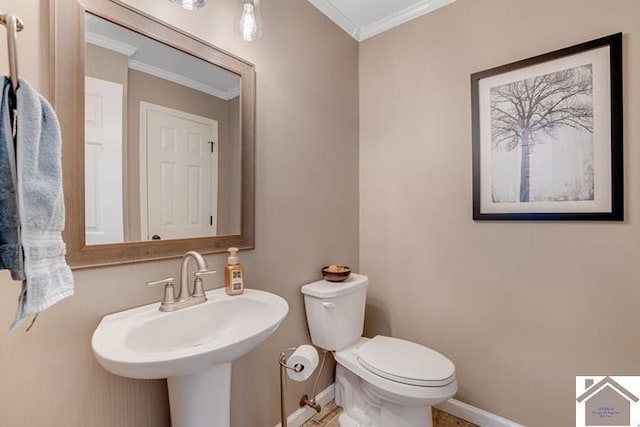 bathroom featuring sink, crown molding, and toilet