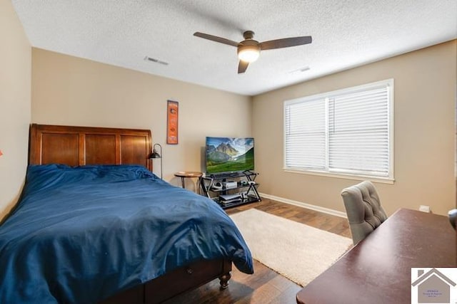 bedroom featuring wood-type flooring, a textured ceiling, and ceiling fan