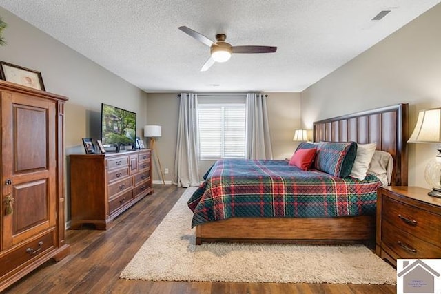 bedroom with dark hardwood / wood-style floors, a textured ceiling, and ceiling fan