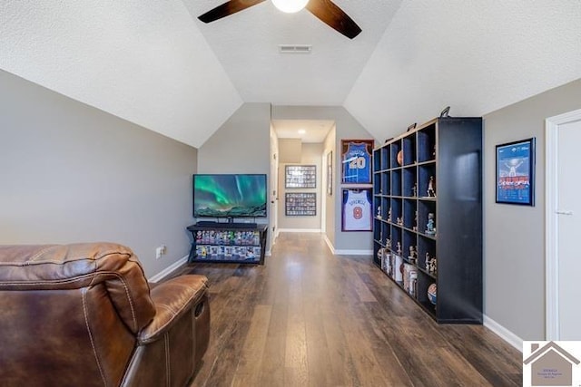 living room with ceiling fan, lofted ceiling, dark hardwood / wood-style floors, and a textured ceiling