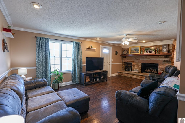 living room featuring ornamental molding, a stone fireplace, dark wood-type flooring, and a textured ceiling