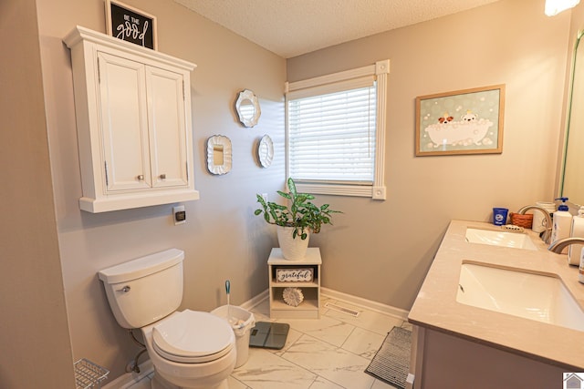 full bath featuring a sink, a textured ceiling, marble finish floor, and toilet