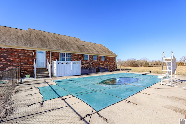 view of pool with a patio area, a covered pool, a water slide, and fence