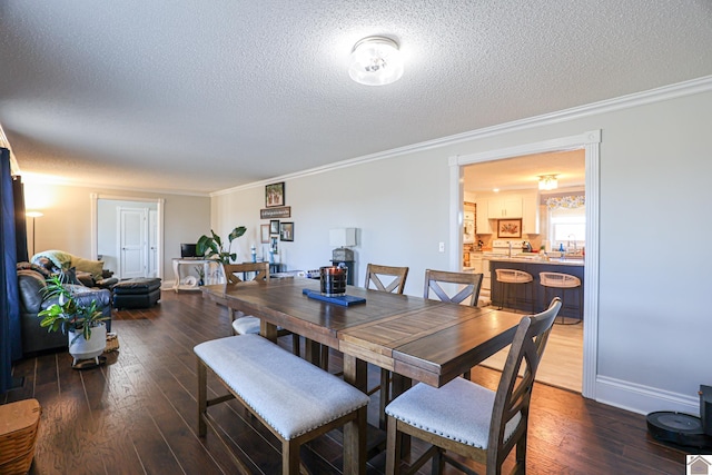 dining area featuring ornamental molding, dark wood-type flooring, and a textured ceiling