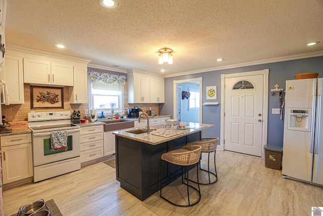 kitchen with a sink, light wood-type flooring, white appliances, and ornamental molding