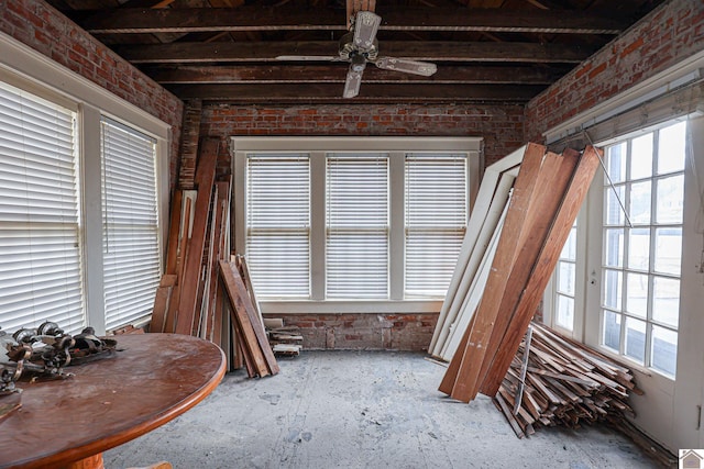 miscellaneous room with plenty of natural light, ceiling fan, and brick wall