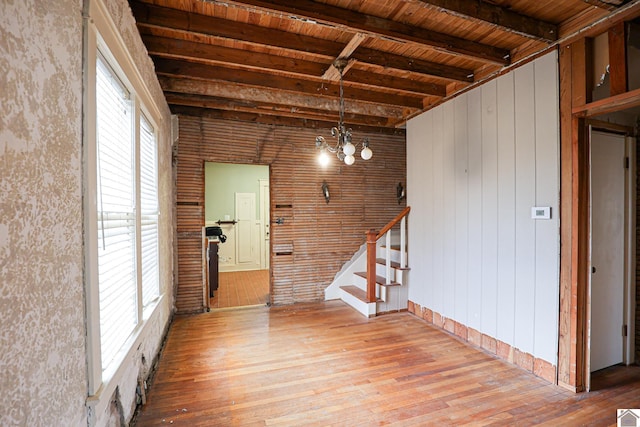 interior space featuring a healthy amount of sunlight, hardwood / wood-style floors, wooden ceiling, and beam ceiling