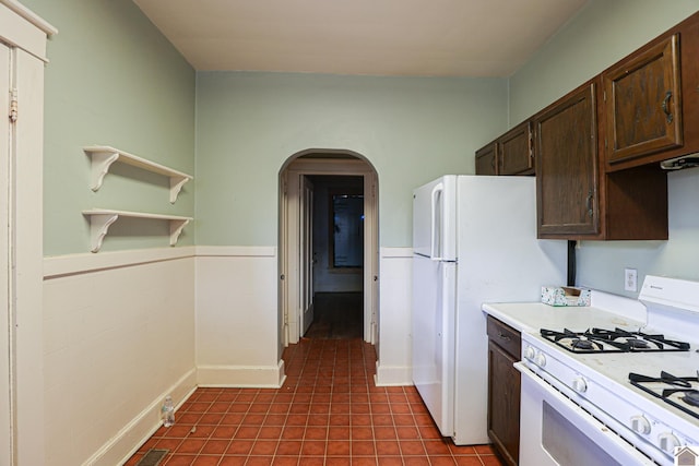 kitchen featuring dark brown cabinetry and white gas range