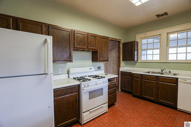 kitchen featuring white appliances, tile patterned floors, sink, and dark brown cabinets